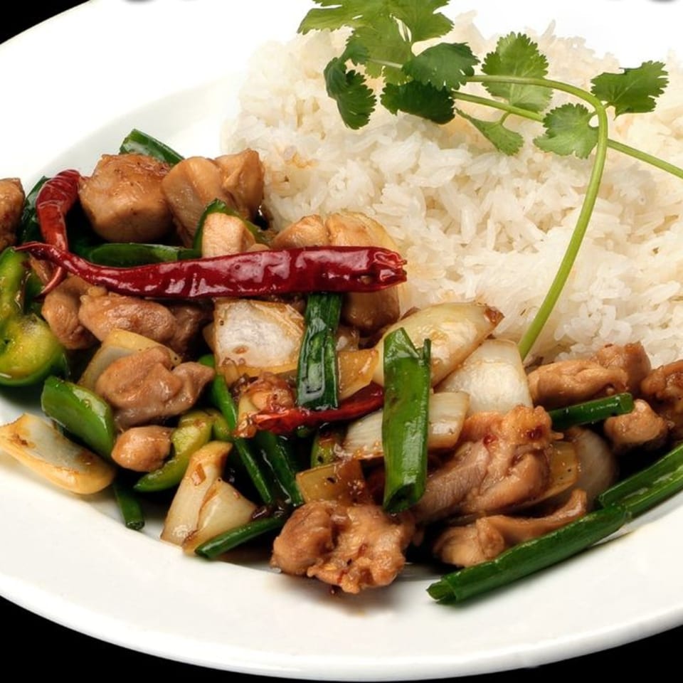 Vietnamese chicken stir-fry with green onions, bell peppers, and chili, served with white rice.